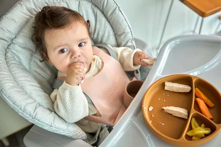 Bebé en asiento para bebé comiendo